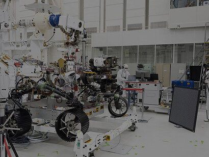In this image, engineers test cameras on the top of the Mars 2020 rover's mast and front chassis. The image was taken on July 23, 2019, in the Spacecraft Assembly Facility's High Bay 1 at NASA's Jet Propulsion Laboratory in Pasadena, California