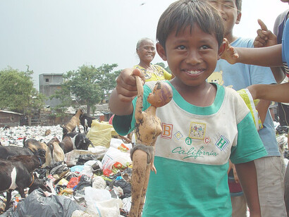 A boy from an East Cipinang trash dump slum shows his find, Jakarta Indonesia