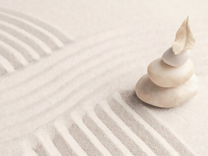 A serene image captures the concept of mindfulness with stacked zen marble stones against a sandy backdrop, inviting viewers to contemplate tranquility and inner peace