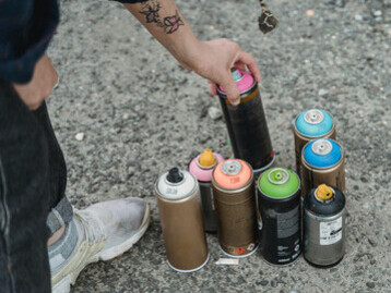 Artista pega lata de spray para iniciar um projeto de arte