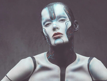A close-up portrait of a woman featuring creative makeup and light effects, set against a dark, textured backdrop