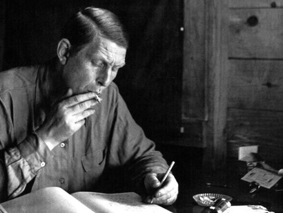 Author W.H. Auden, writing at his desk