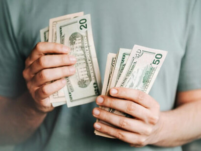 A person couting US dollar bills