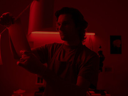 The world of photography as a man skillfully develops photos in a captivating red room, where creativity meets precision in capturing timeless moments