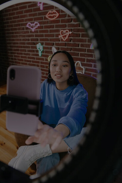 An influencer creating content with a smartphone and professional lighting