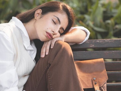 A woman sleeping on a park bench highlights the increasing laziness prevalent in modern society