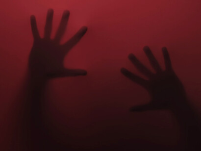 Eerie silhouettes of hands cast in a haunting red glow