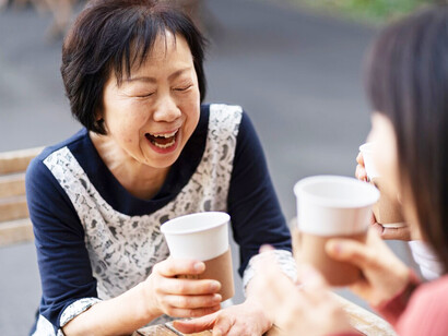 At a local coffee shop, middle-aged Korean women bond over conversation and laughter, savoring their drinks as they cherish the warmth of friendship