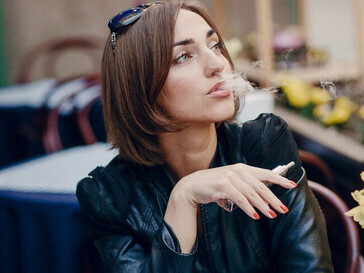 A woman vaping casually outside in the fresh air
