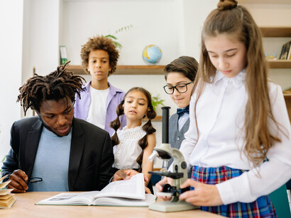 A young teacher helping his students