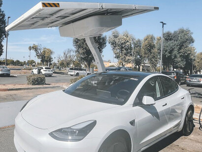 The electric car, currently being charged, is a shining example of decarbonization efforts, drawing power from renewable energy sources as part of a broader initiative for green projects