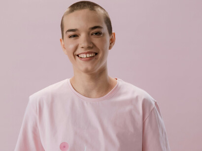 A recovering cancer patient in a pink shirt, smiling
