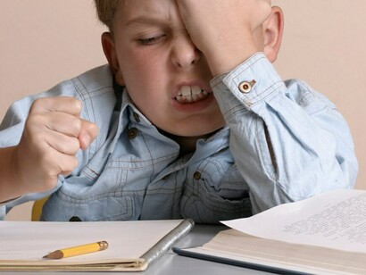 Niño furioso ante un cuaderno