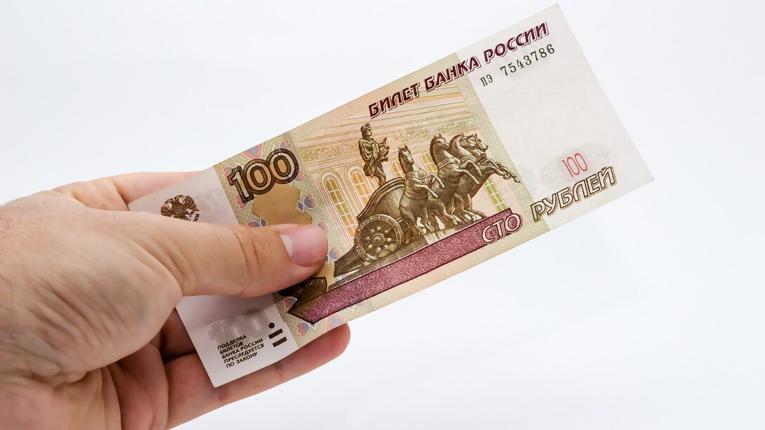 Person holding cash over a white isolated background, showcasing financial assets