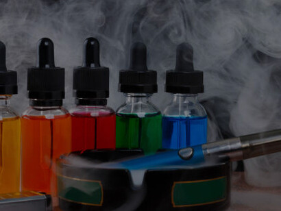 Electronic cigarette ashtray, lighter, and a bottle of vape liquid arranged on a black background