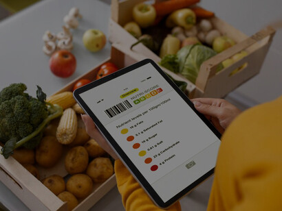 Woman utilizes her phone to scan barcodes for nutritional details while exploring different vegetable options