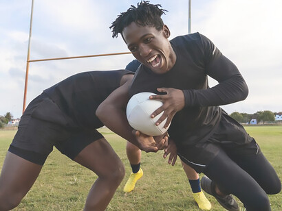 Exciting scene of men playing rugby on a field in Kenya, capturing the passion and intensity of the sport in action
