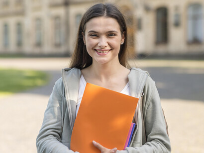 A young university student, carrying her books and notebooks