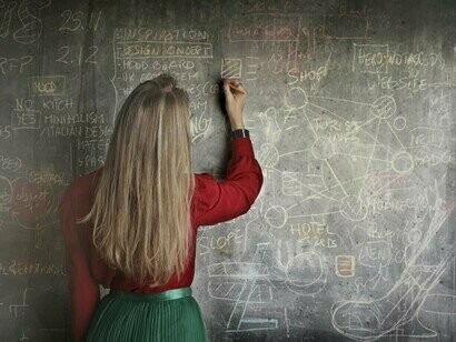 Un'insegnante che scrive alla lavagna