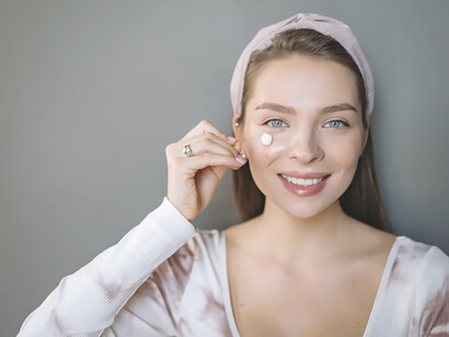 Experience the art of skincare routine essentials as a woman gently massages cream onto her beautiful face, unveiling the secret to youthful skin