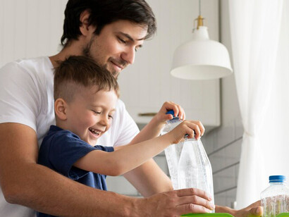 A man and a child enthusiastically engage in recycling, highlighting the importance of teaching sustainable practices and environmental responsibility for future generations