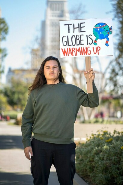 "El globo terrestre está recalentado", joven portando una pancarta en la calle