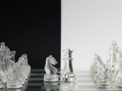 Crystal-clear chess pieces arranged on a polished chessboard
