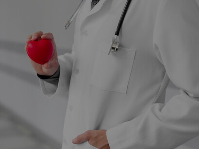 A doctor with a plastic heart, illustrating the link between cardiovascular health, positive thinking, and mental wellness