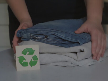 Garment recycling: Stack of clothes on recycling table for collection