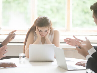 Gender discrimination in the workplace: a female employee subjected to ostracism and condescension by male peers, highlighting ongoing challenges of inequality