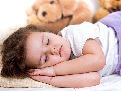 Niña apretando los dientes mientras duerme