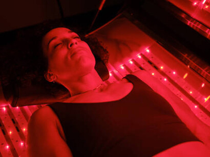 A woman undergoing red light therapy while lying on an LED bed for enhanced healing and rejuvenation