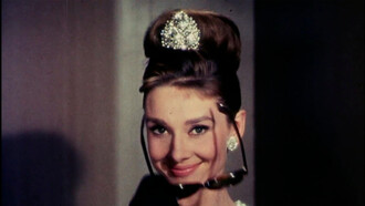 Audrey Hepburn no filme Breakfast at tiffany's. O colar de pérolas traz a elegância e o luxo, os óculos trazem o toque descolado e jovial.