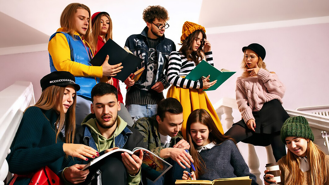 A group of cheerful students sitting together in a lecture hall before class, exemplifying cultural exchange and multicultural education