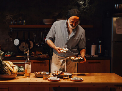 A man on a kitchen, getting ready to serve different dishes
