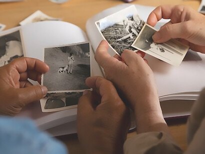 A couple immersed in fond nostalgia as they leaf through a photo album, exploring the rich tapestry of their ancestors and family history