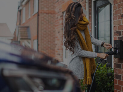 In the UK, a woman charges her car with carbon-neutral and environmentally friendly energy, reducing her carbon footprint