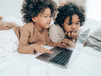 Young boys glued to a laptop, distracted by the happenings on the screen
