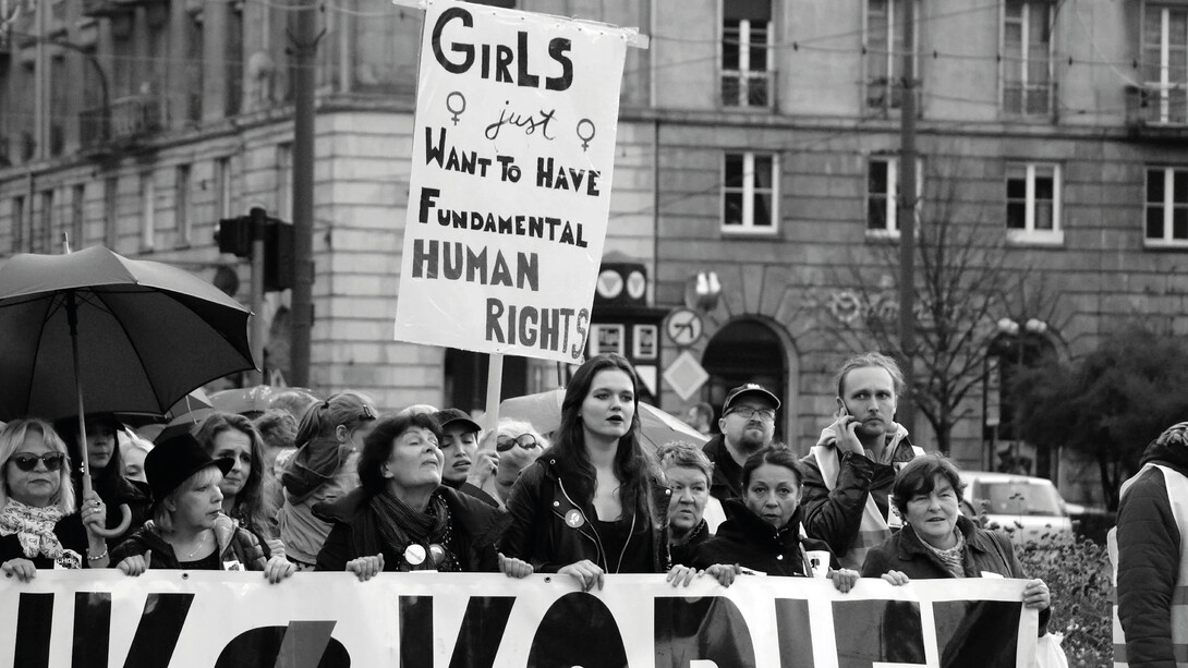 Women march together, proudly holding a banner that reads: "Girls Just Want to Have Fundamental Human Rights