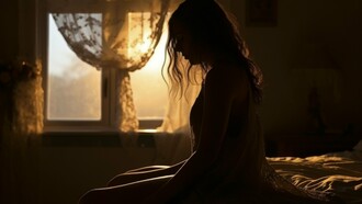 A woman sitting silently in the glow of a fading sunset, reflecting the loneliness that lingers after heartbreak
