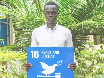 Tabann de Bol, a South Sudanese volunteer holding the SDG of peace and justice