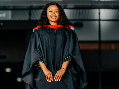 A young woman in her academic regalia