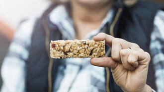 A woman’s hands holding a protein bar
