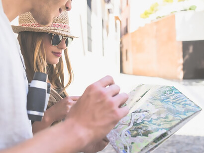 Lost couple seeks guidance in the bustling cityscape, referencing a map as they navigate through unfamiliar streets, a relatable experience for urban adventurers