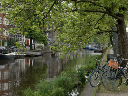 A view of one of the city's canals, trees and vegetation abound, Amsterdam, Netherlands