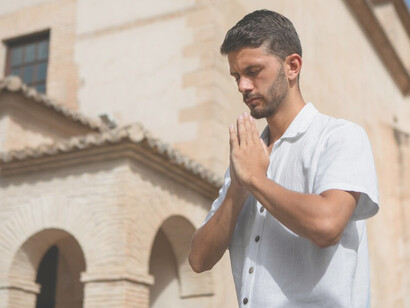 A young man engaged in prayer, reflecting on his faith and creed