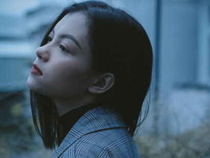 A young, black haired woman in a meditative mood