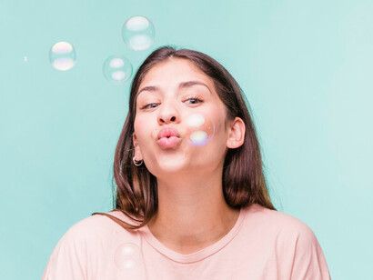 A beaming girl happily plays with floating soap bubbles, her infectious joy creating a magical atmosphere around her