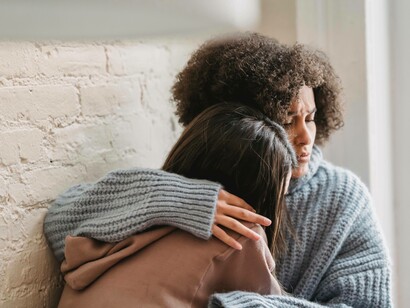 A woman consoling her friend after they've been through a difficult situation