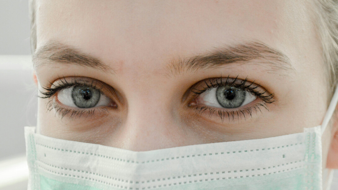 Close-up of a female doctor's eye as she wears a protective mask, conveying focus and determination